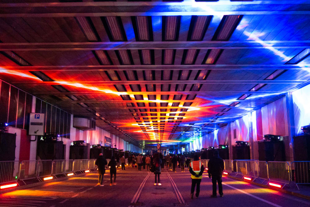 A photo looking straight down the covered Beech Street. The photo is dark, with red and blue lights on the ceiling, receding into the distance.