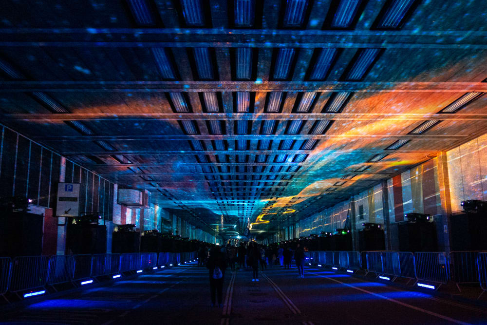 A photo looking straight down the covered Beech Street. The photo is dark, with a projection of a solar system on the ceiling.