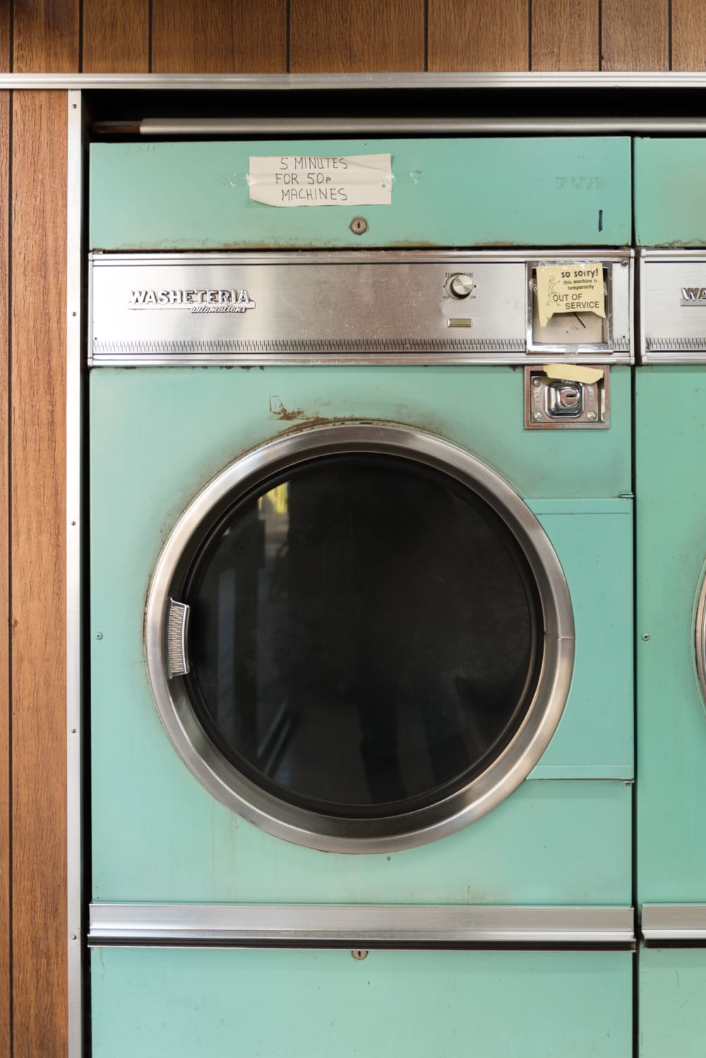 A photo of a vintage washing machine in a laundromat.