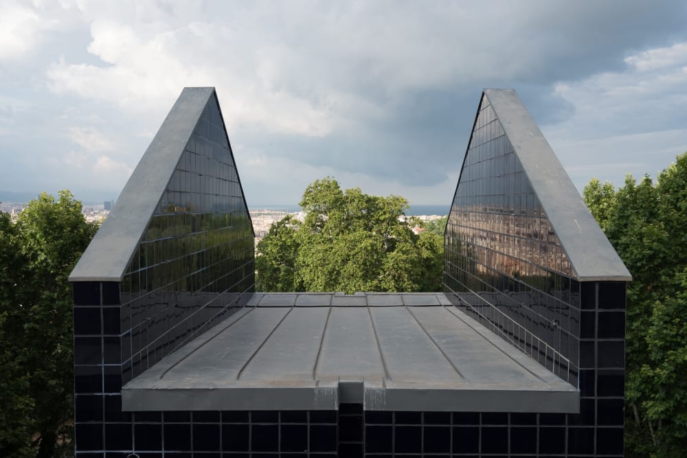 An open air photo of two tiled walls. They’re perpendicular to each other and each end is slanted like the roof of a building.