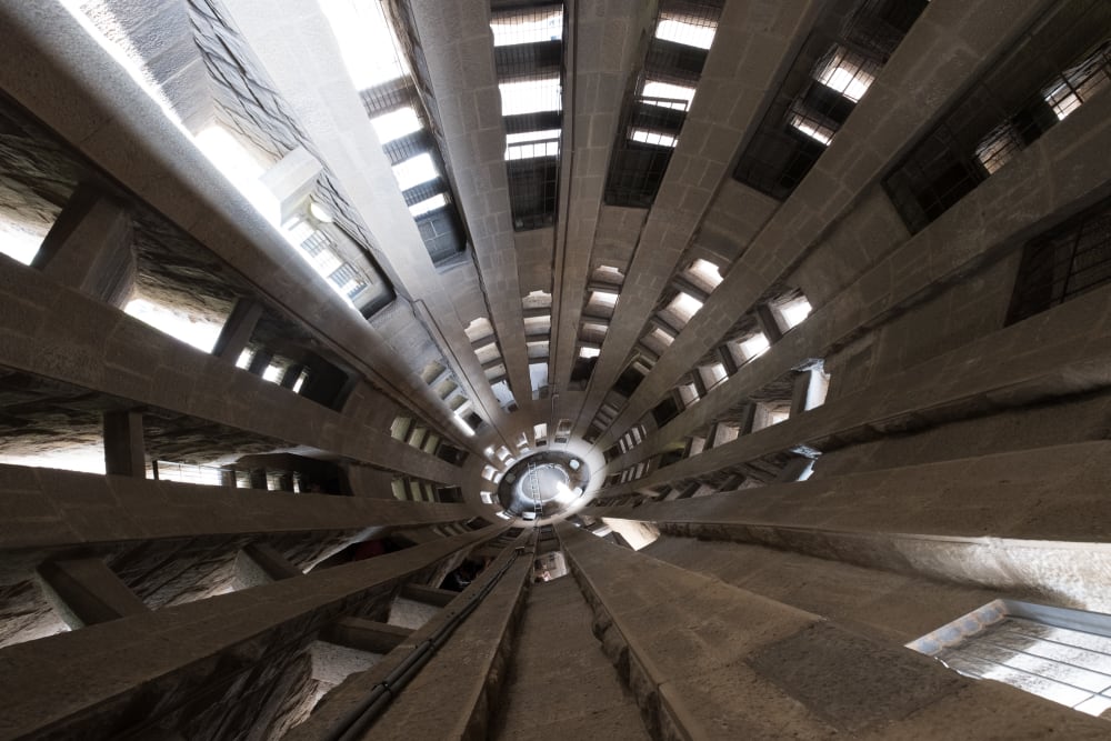 A wide angle photo looking down void of the interior of one of a la Sagrada Família tower.