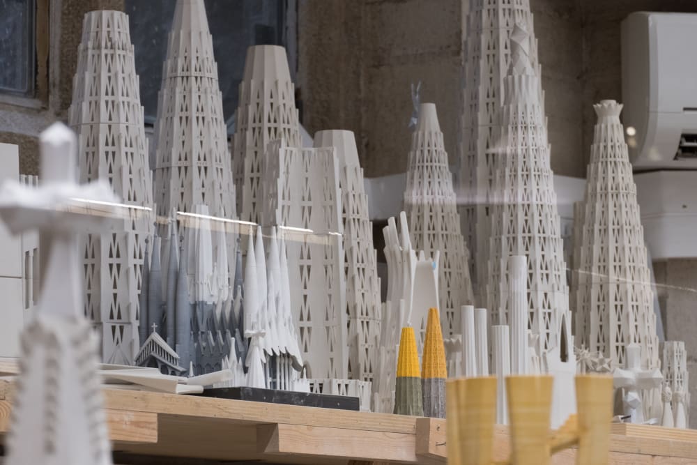 A photo of many small white models of roof spires of la Sagrada Família.