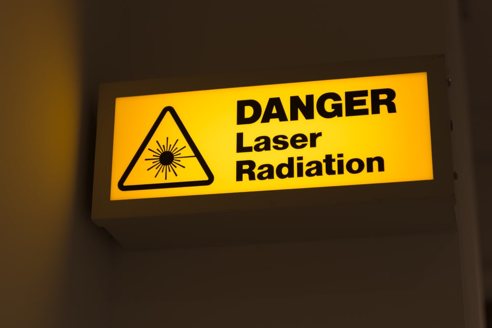 A photo of a lit sign that reads ‘Danger - laser radiation’