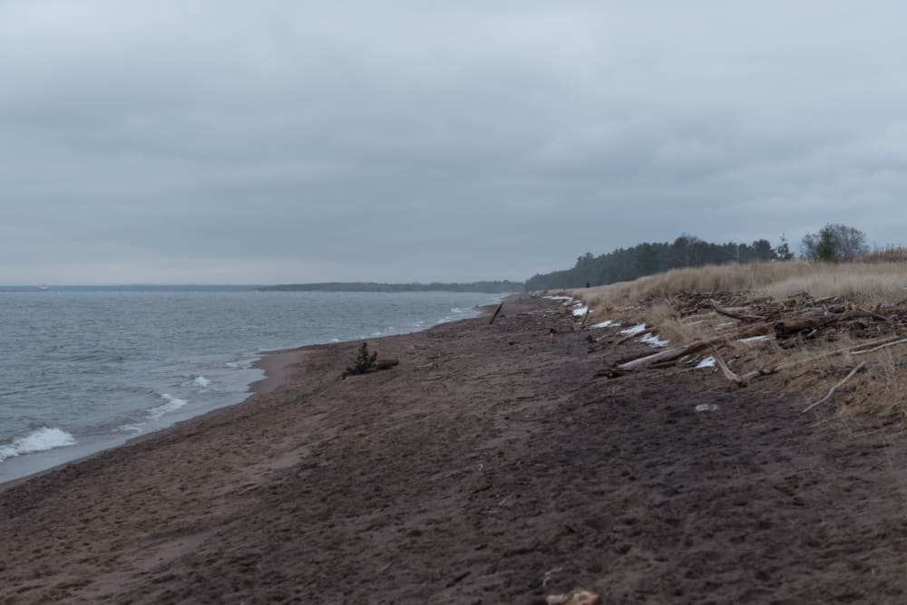 A photo from a grey beach looking along the shore.