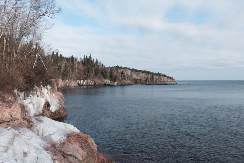 A photo from the shore of Lake Superior, looking East. There’s snowy frocks on the right.