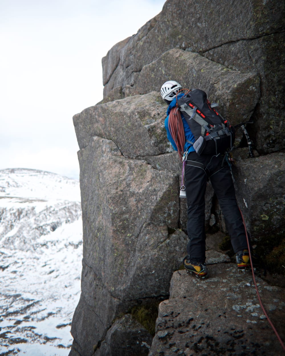 Our instructor gets placing climbing equipment on the edge of an overhang on Fiacaill ridge.