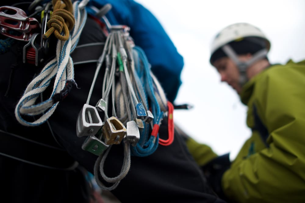 A macro photo of climbing gear on our instructor’s harness. Chris is visible in the background.