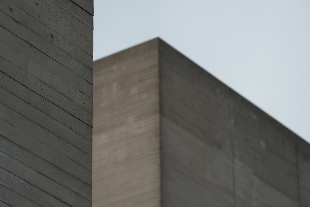 A close detail of a section of the National Theatre’s roof. In the foreground is the edge of a corner of concrete with wood effect. In the background another building roof can be seen slightly blurred.