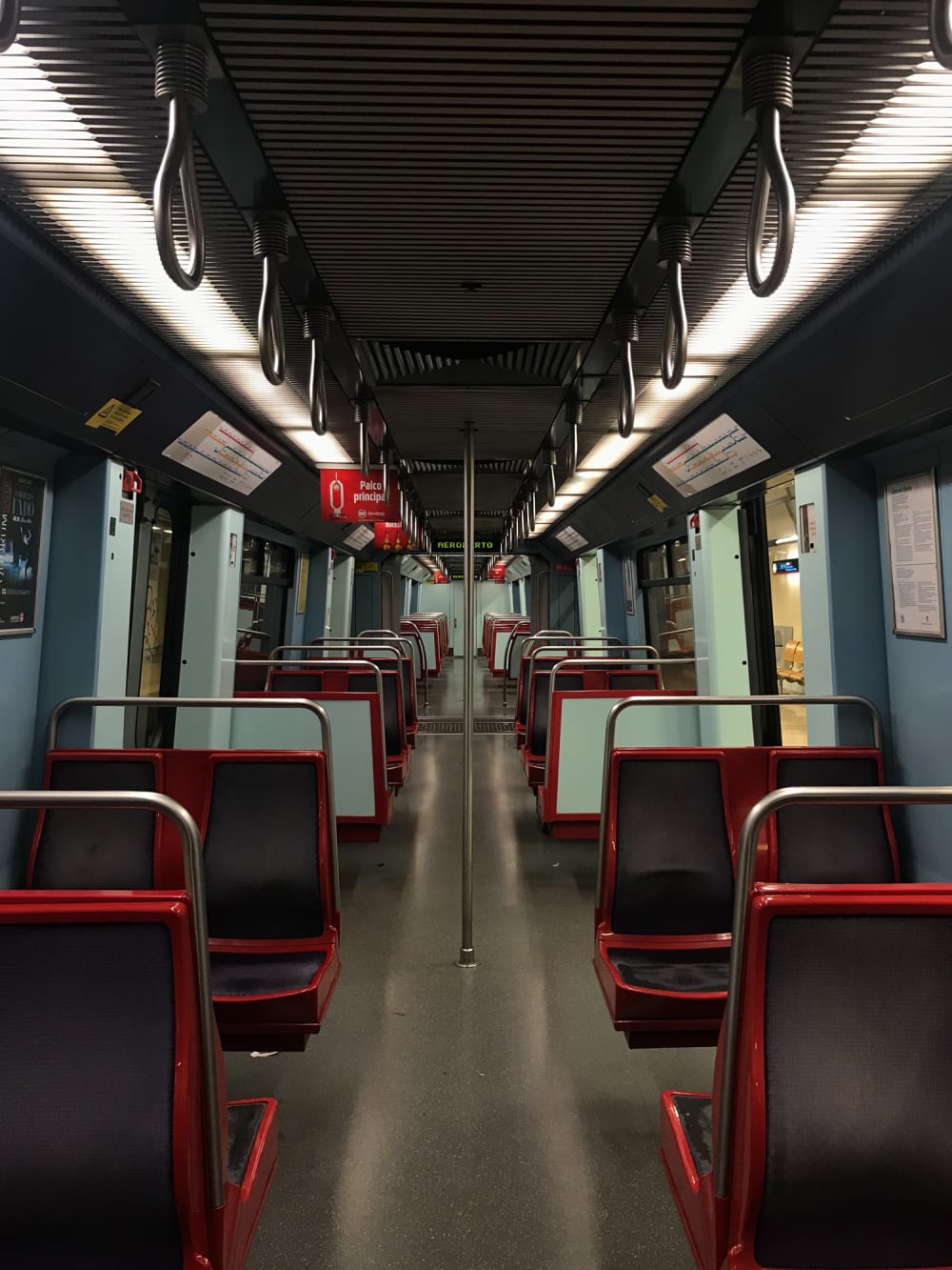 Looking straight down an empty underground train.