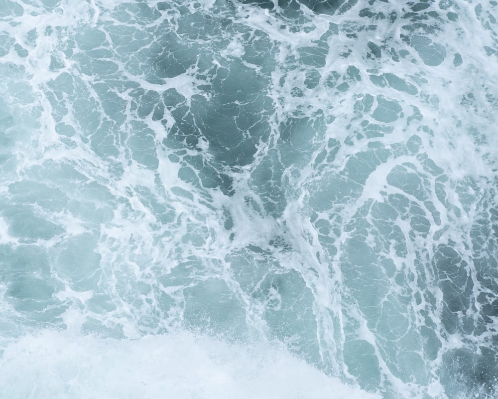 A photo looking down on choppy sea water from above.