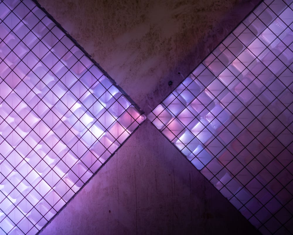 A close photo of a light sculpture. It is made up of small light coloured cubes which are glowing shades of blue and pink.