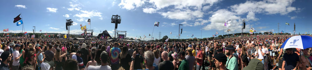 A panorama of a crowd of people in front of the Pyramid stage.