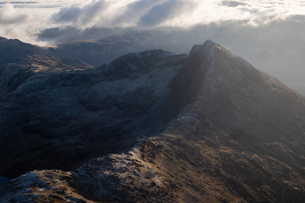 A ridge leads from the left to the right from Snowdon to the peak of Y Lliwedd.