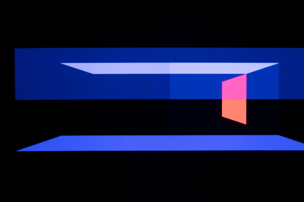 Geometric shapes fill the field of view horizontally. They’re various shades of blue. One pink trapezoid is on the right.