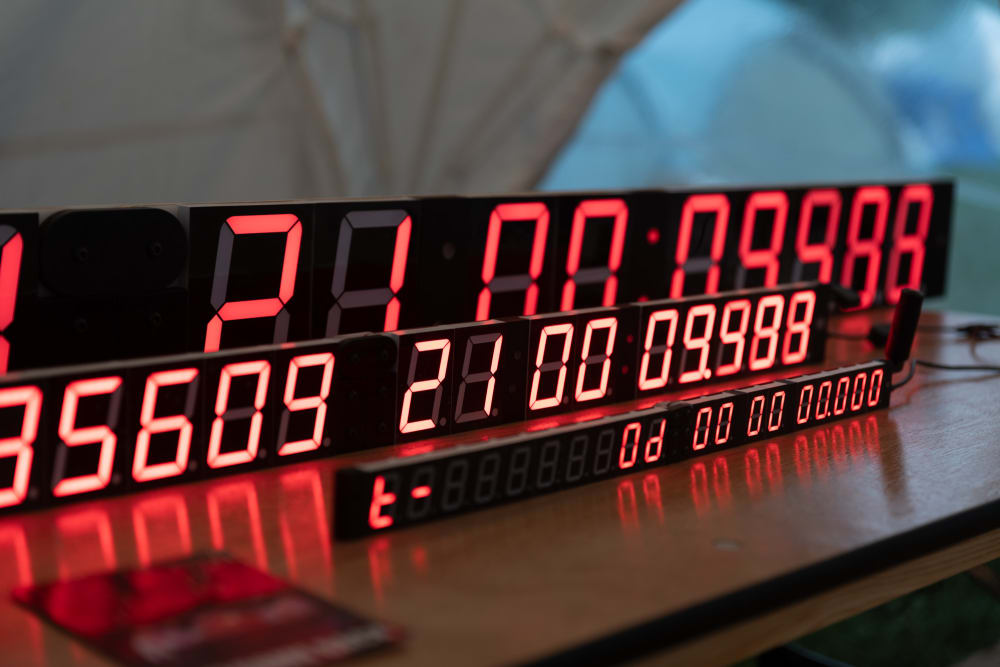 Three rows of red seven segment displays one behind the other make three highly precise clocks.