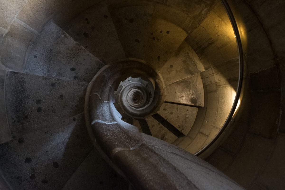 Looking directly down a tight stone spiral staircase