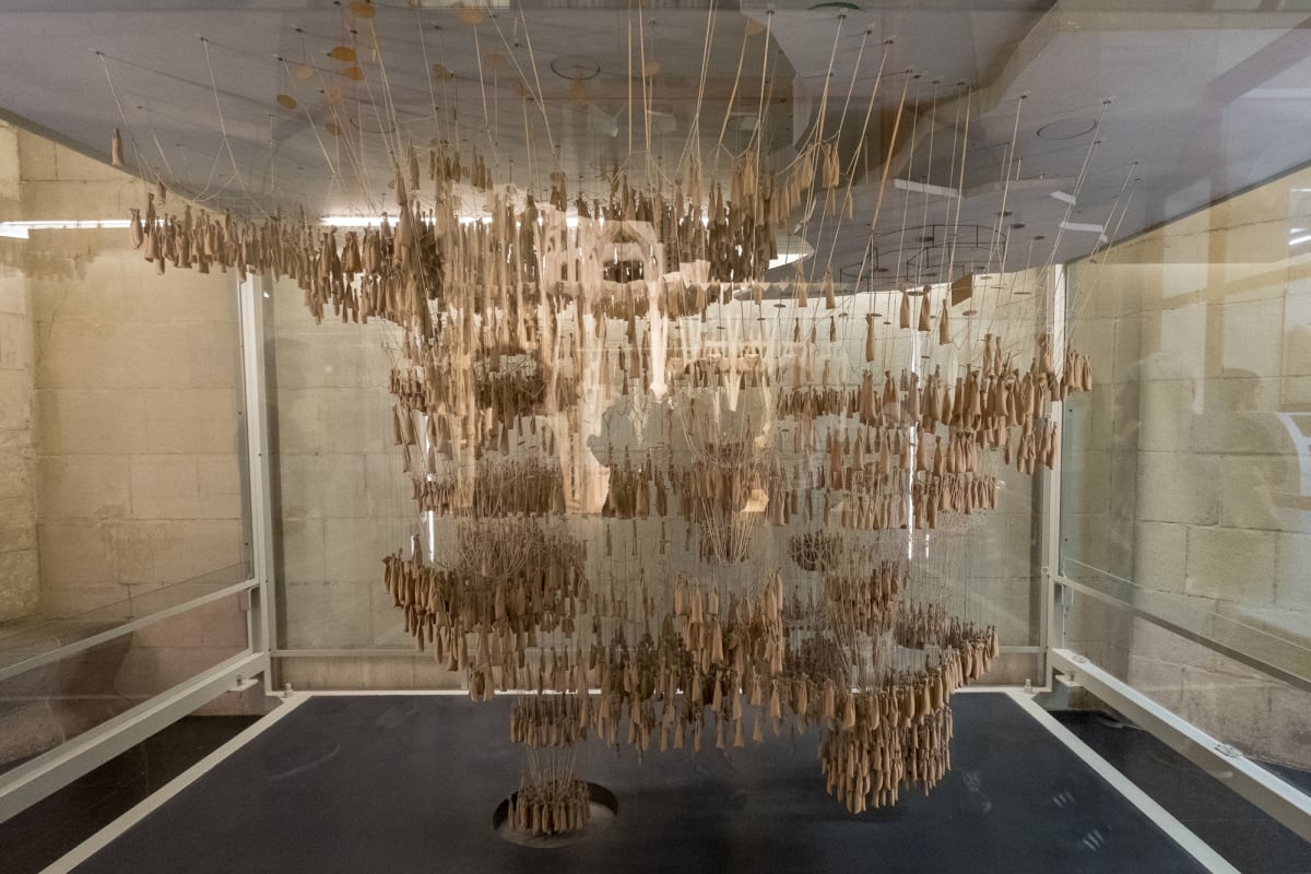 A photo of an original construction prototype made for la Sagrada Família. The model has hundreds of small weights hung from loops of string forming catenary curves. The shape of the curves helped determine the arch shapes and position of supports.