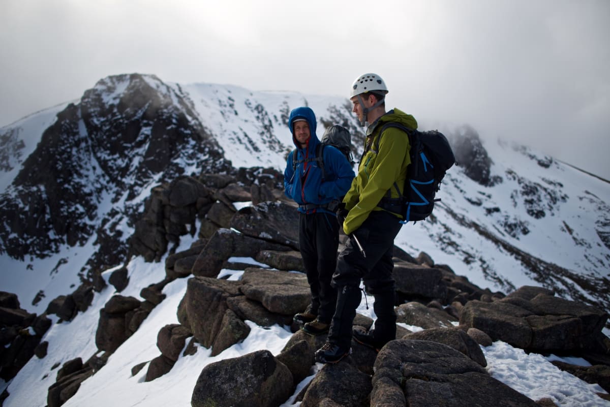 Chris and our instructor stand on a level section of Fiacaill ridge. There’s low cloud on the mountain, but some sunlight just breaking through.