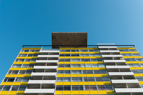 Looking up at the top of a tower block on the Golden Lane estate. The block has contrasting patches of bright white and yellow.