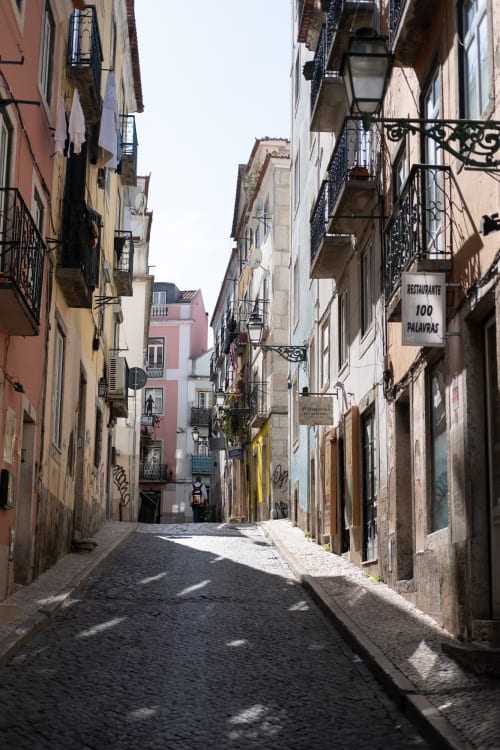 Looking up a narrow street in bright sunlight.