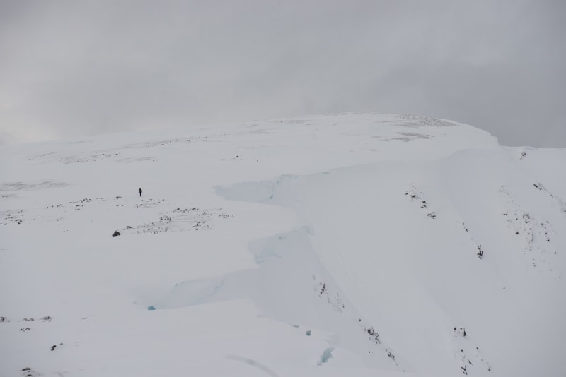 Ed in far distance is a dark spec on an otherwise white mountain.