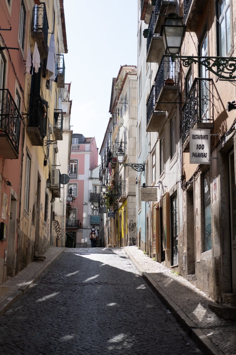 Looking up a narrow street in bright sunlight.