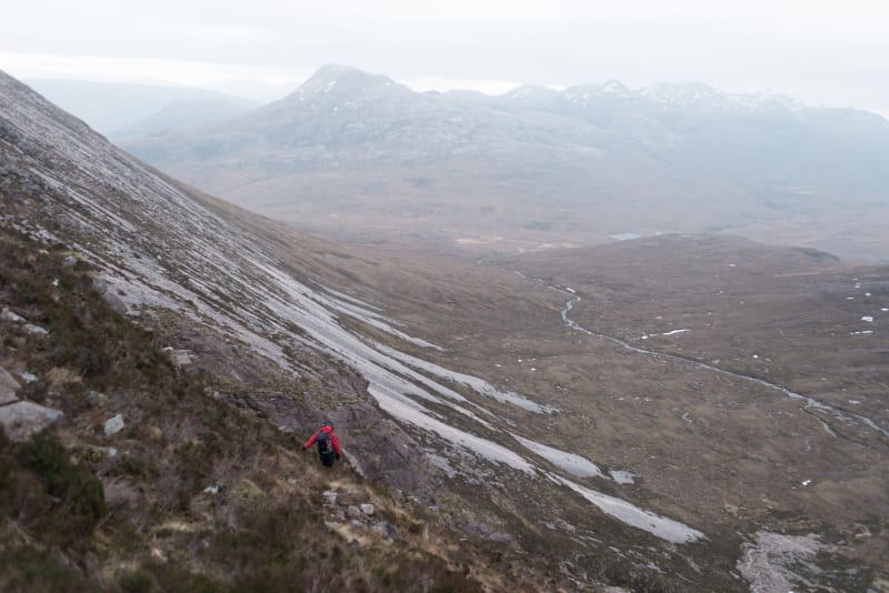 A photo taken from mid-way up Beinn Eighe, pointing down. Chris is ahead, descending the mountain.