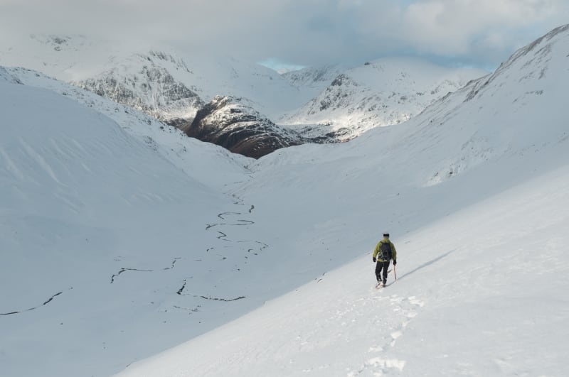 Chris descending in to the bowl of the Ring of Steall. It’s later in the day and the sun is low in the sky. The bowl is already in shadow. There’s a small windy stream at the base of the bowl.