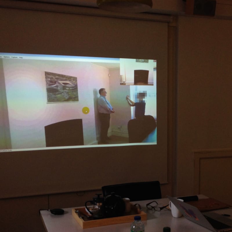 A photo from a user research session. A user is attempting to take a passport-style photograph.