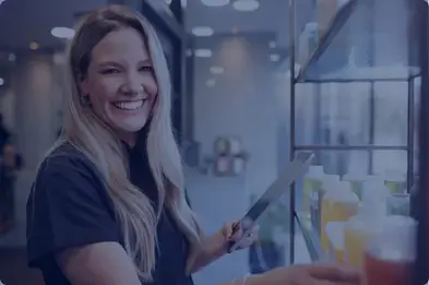 woman smiling taking inventory at her business