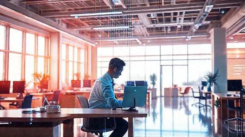 Trabajador concentrado en un entorno de oficina ergonómico y biofílico