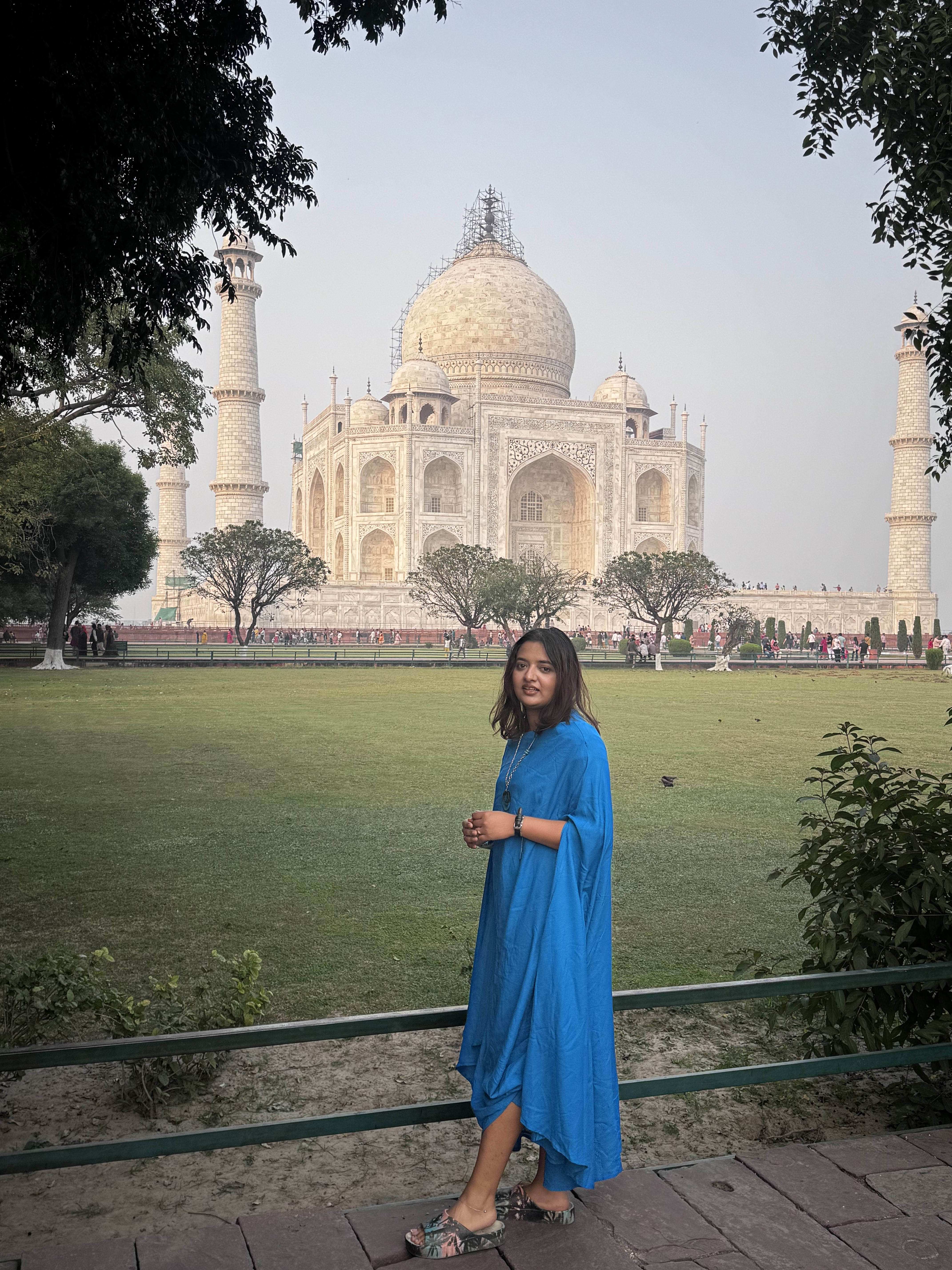 A traveller in blue on the lawns in front of the Taj Mahal