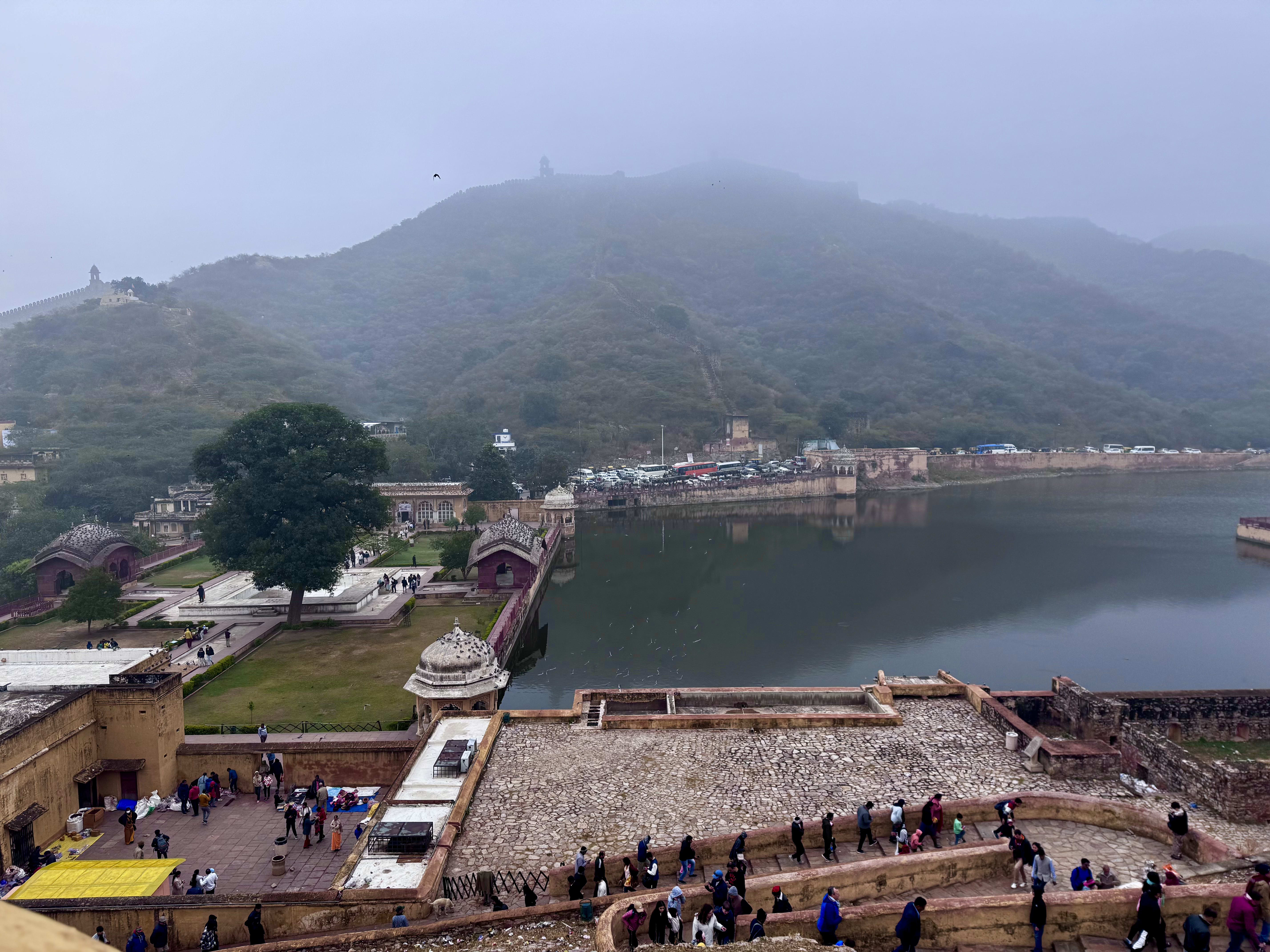 A lakeside town with ghats and a hilltop temple beyond