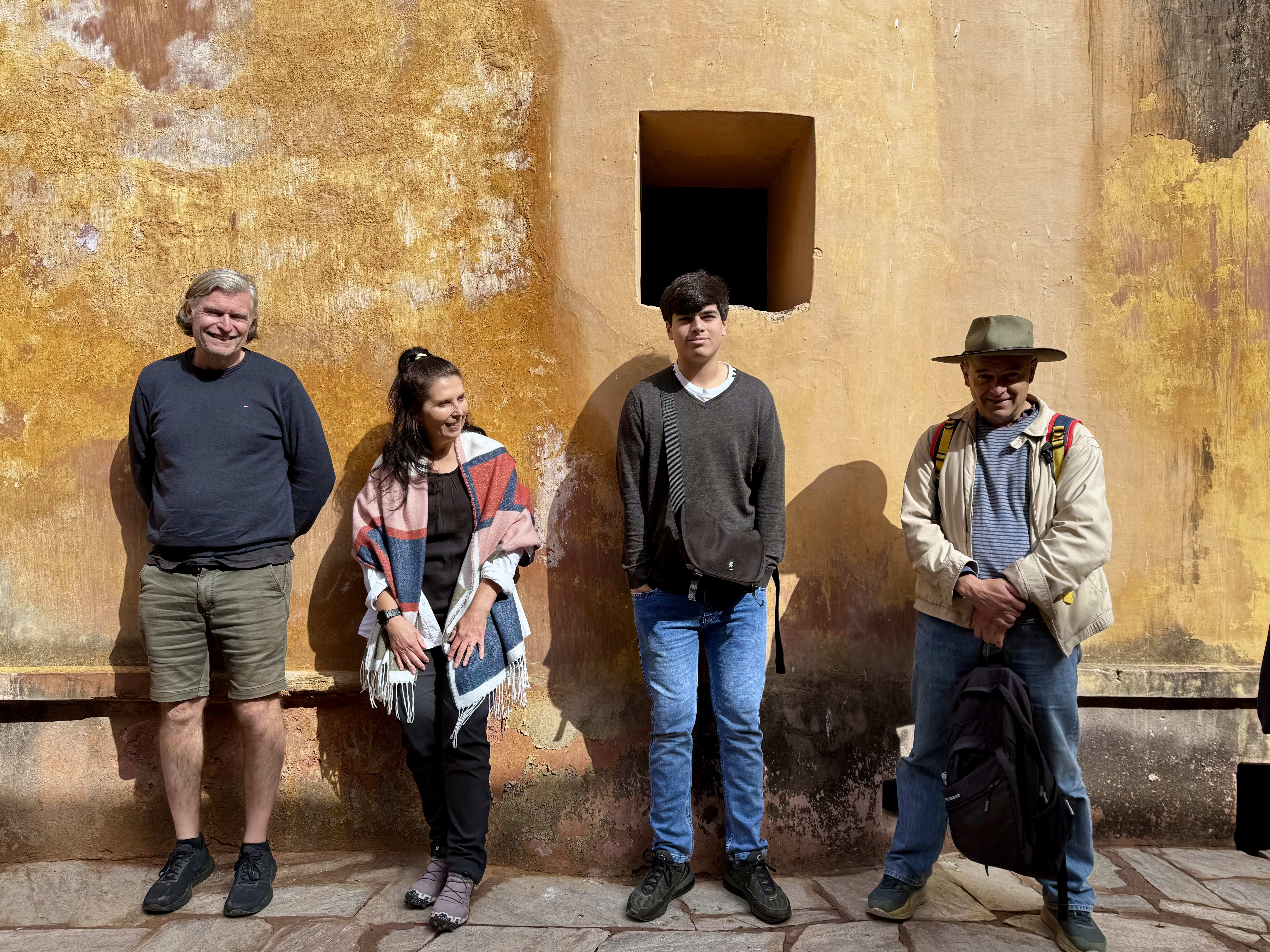 Local men outside a yellow village wall