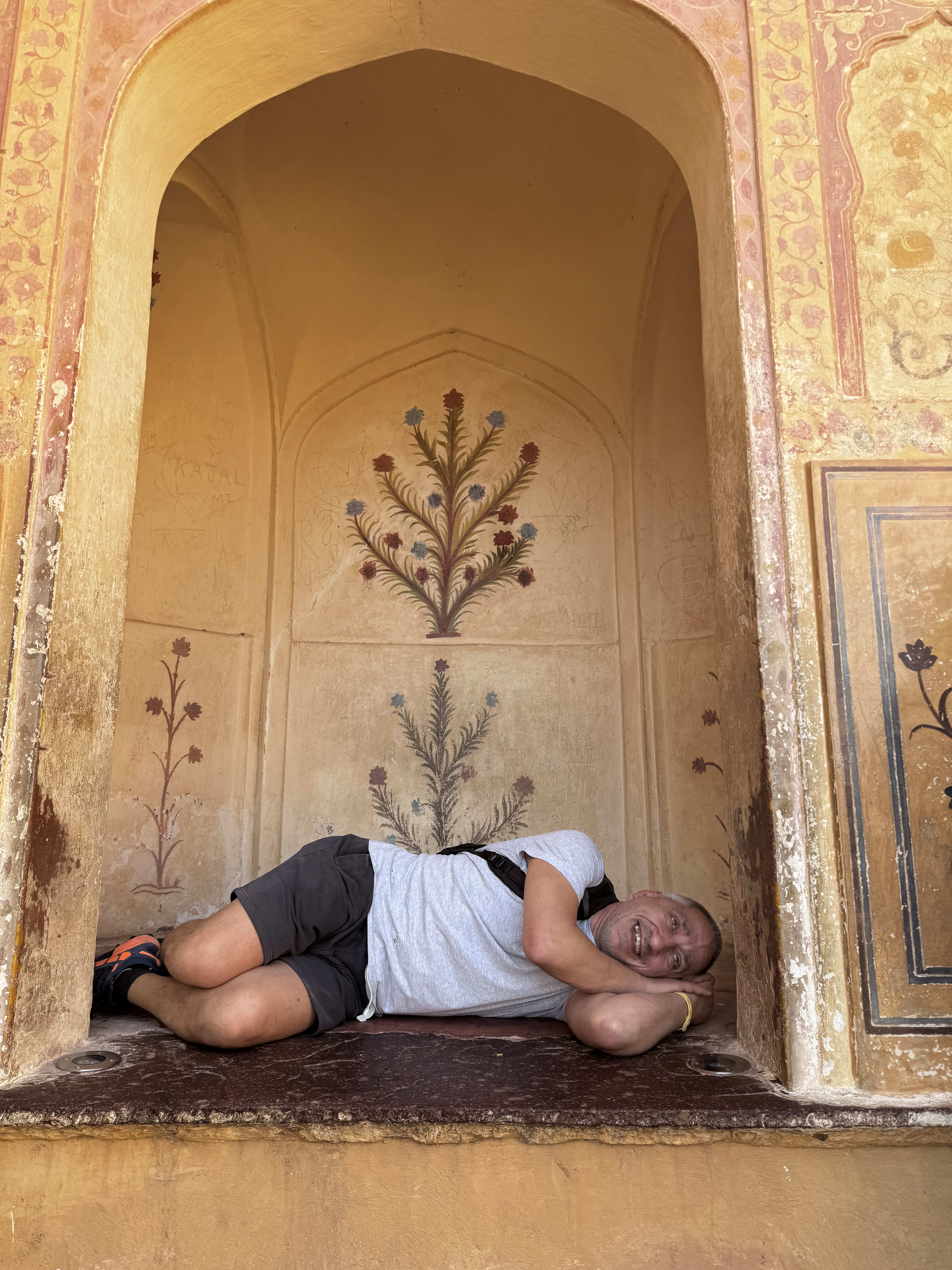 A traveller clowning beneath a painted arch