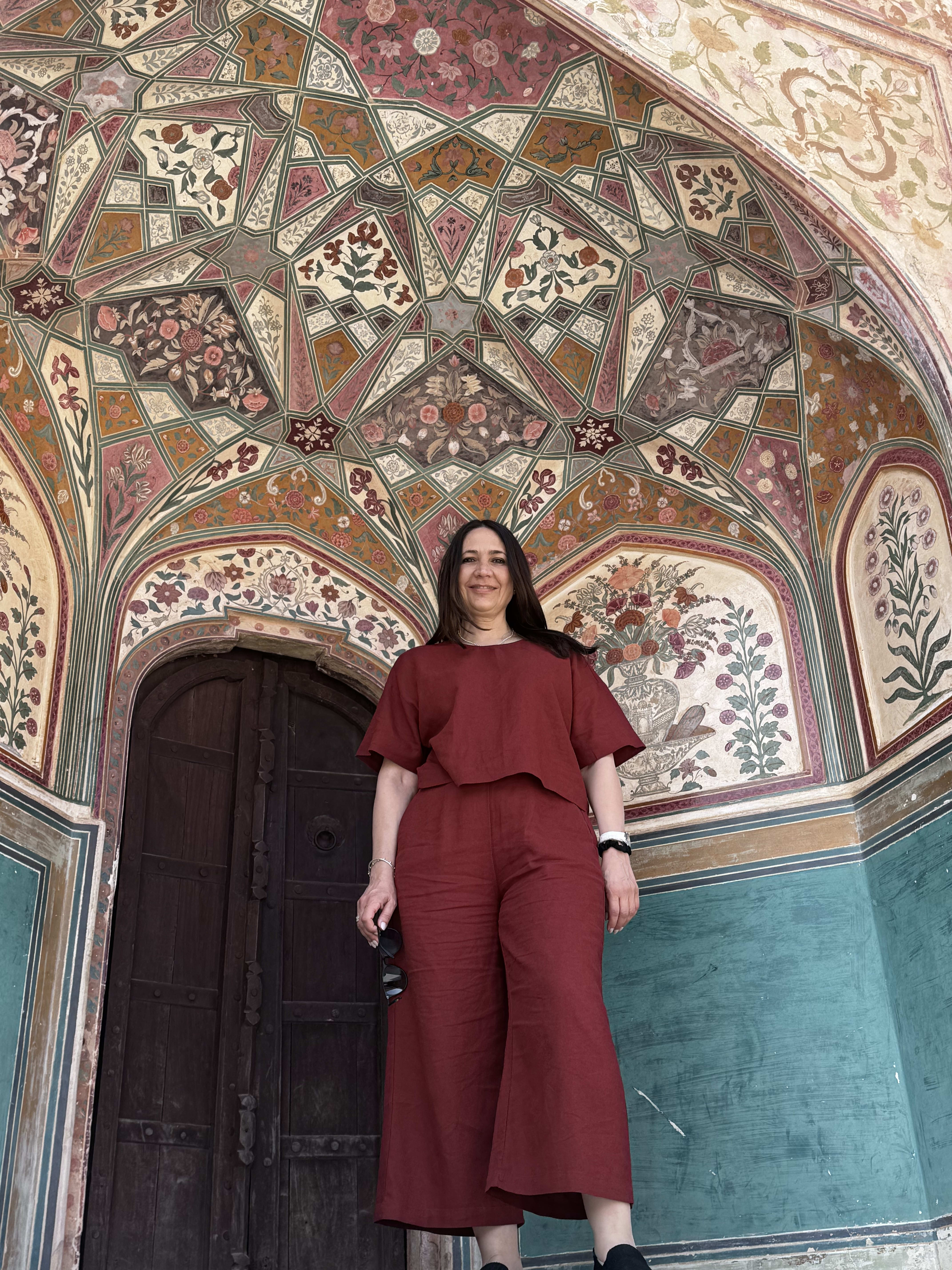 A traveller in front of the painted Ganesh Pol gateway at Amber Fort