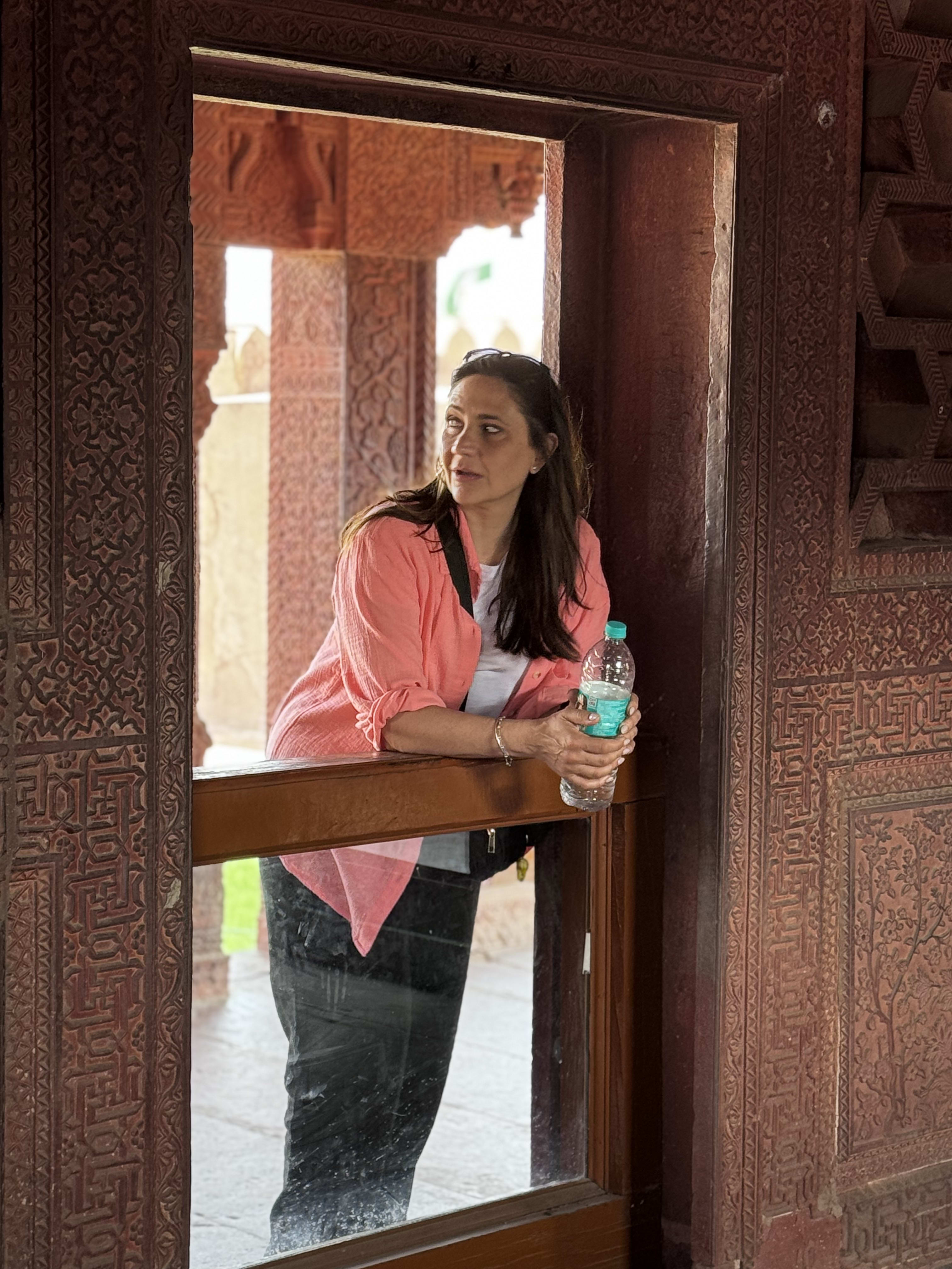 A traveller leaning on a carved stone window frame