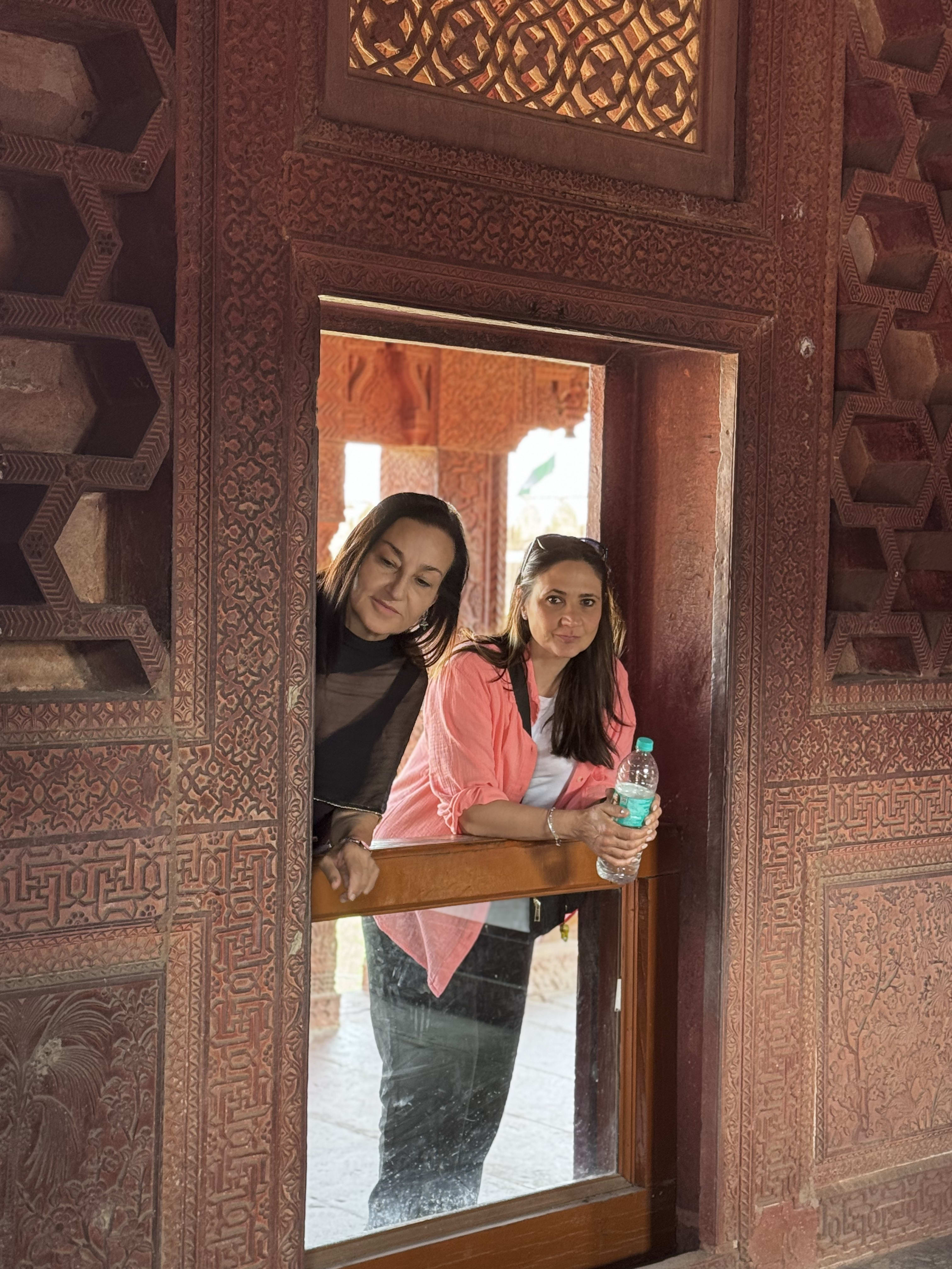 Two travellers standing in a carved sandstone doorway