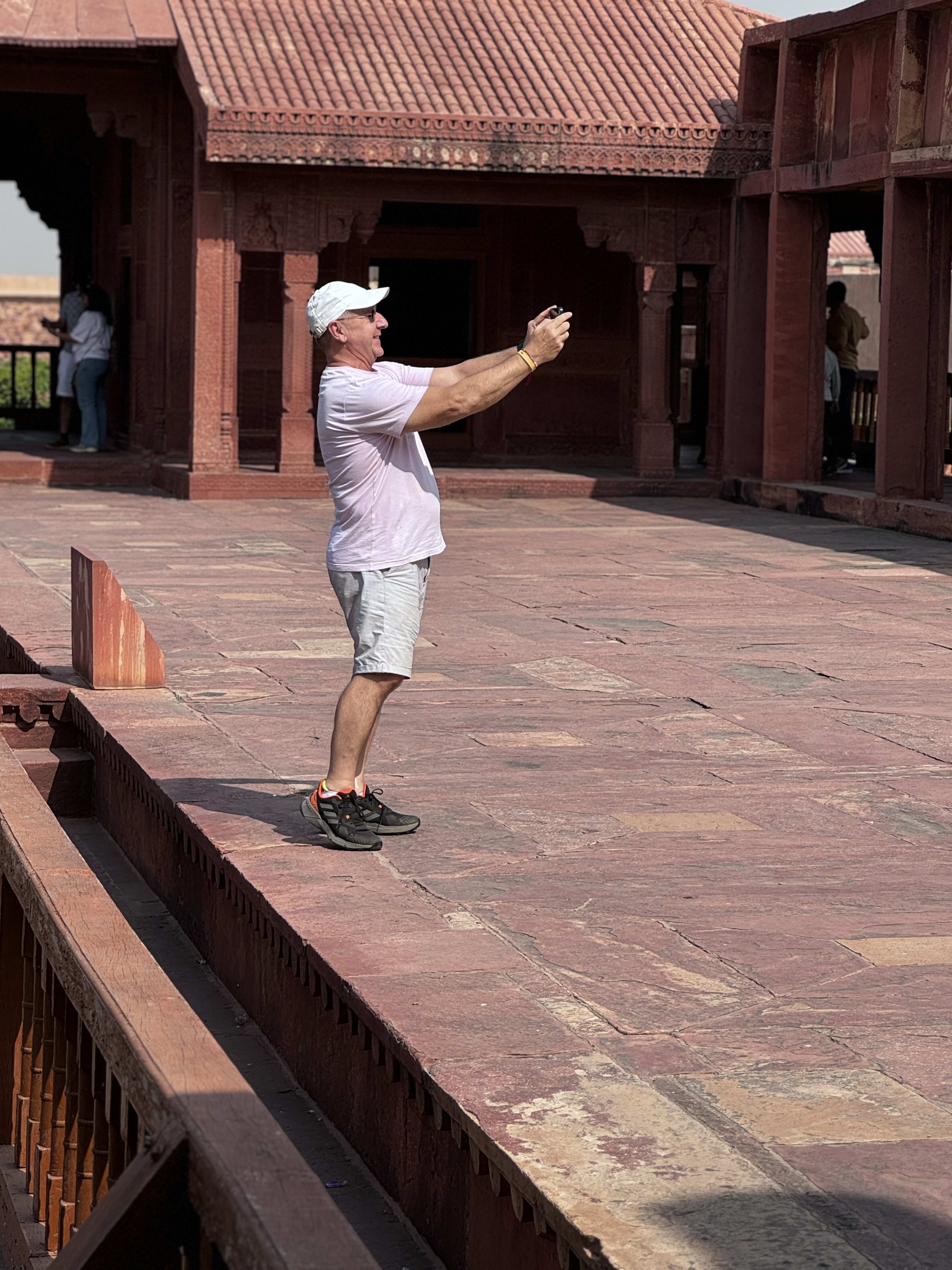 A traveller taking a photo at a red sandstone monument