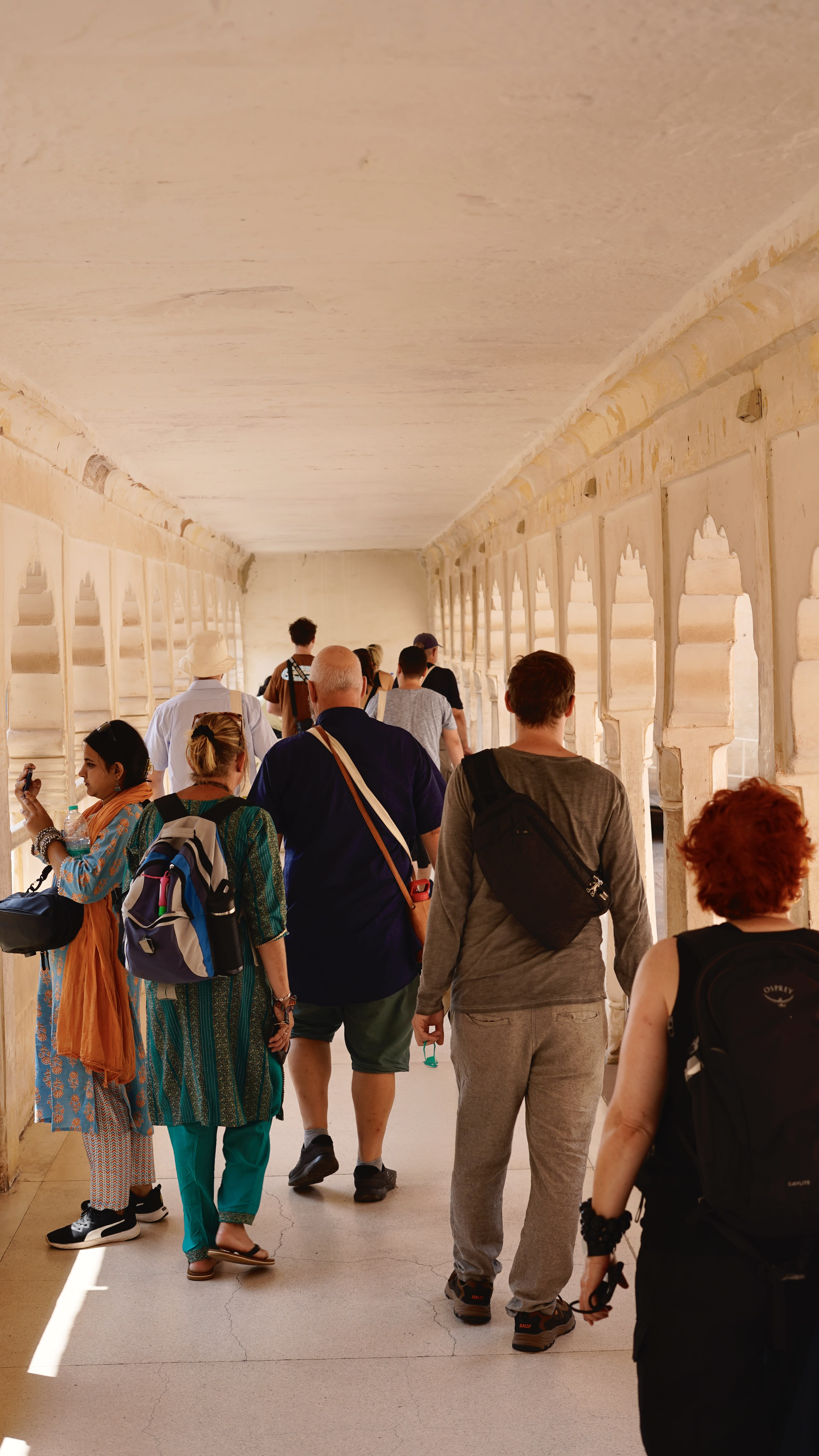 Visitors in a shaded palace colonnade