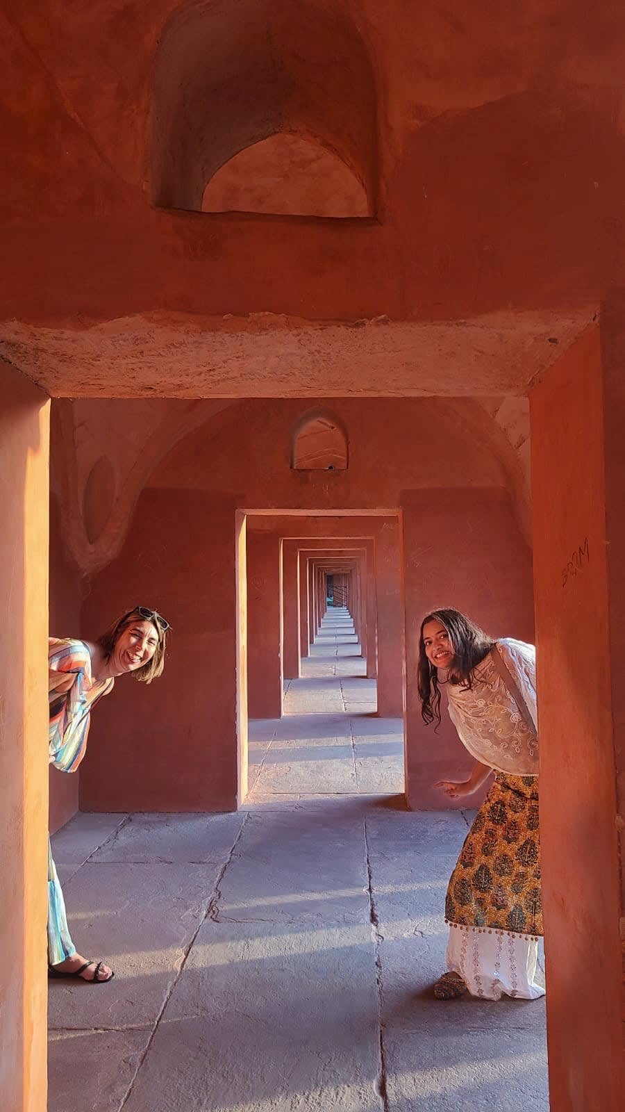 Travellers in the red sandstone corridors of Fatehpur Sikri