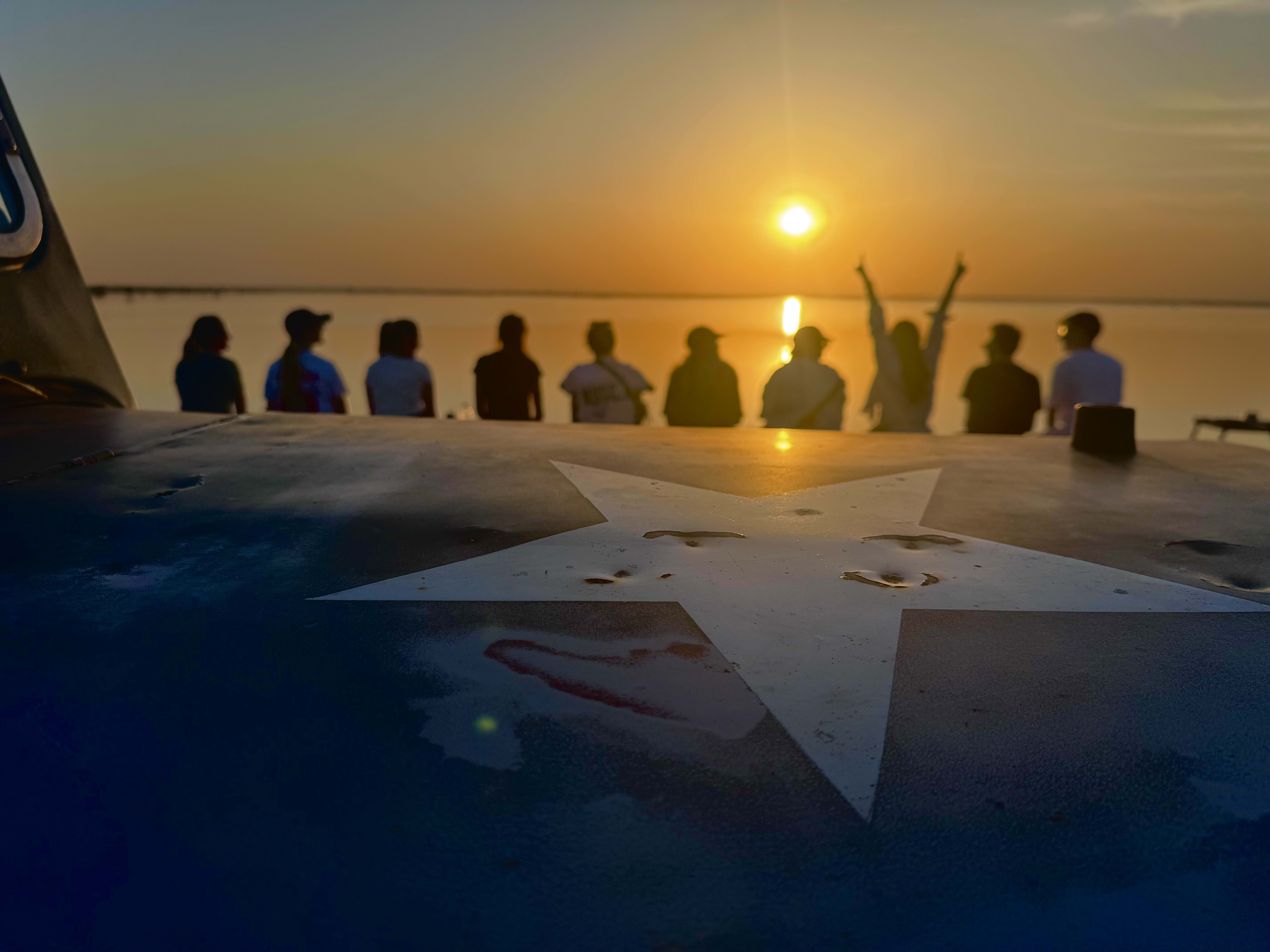 Travellers watching the sun go down from a rooftop