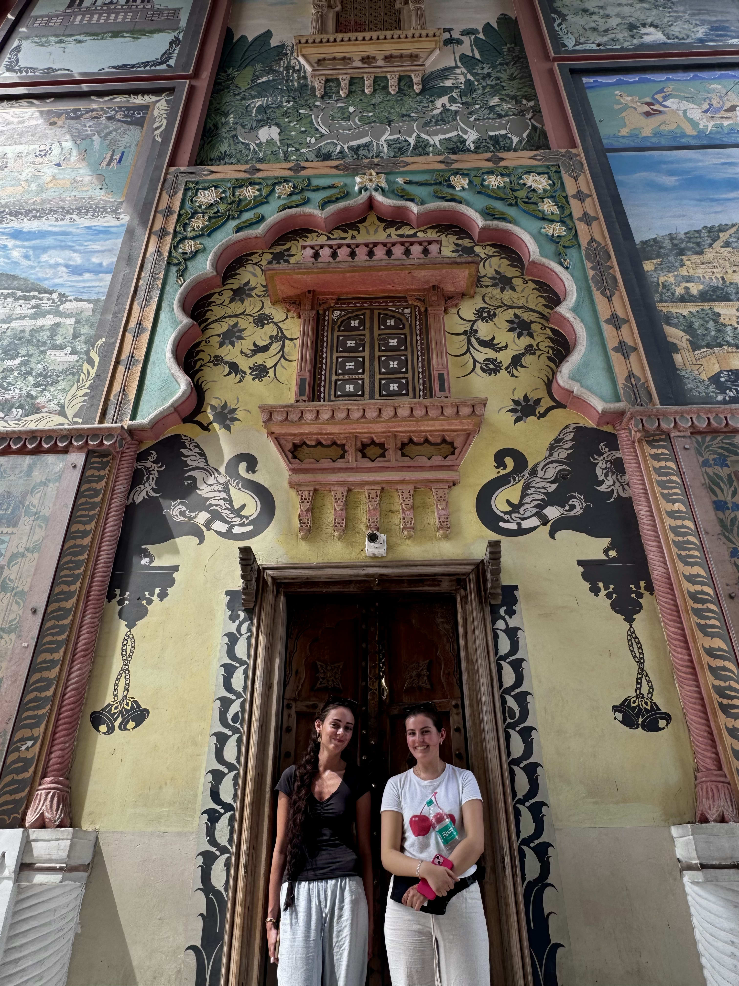 A painted haveli facade with travellers below