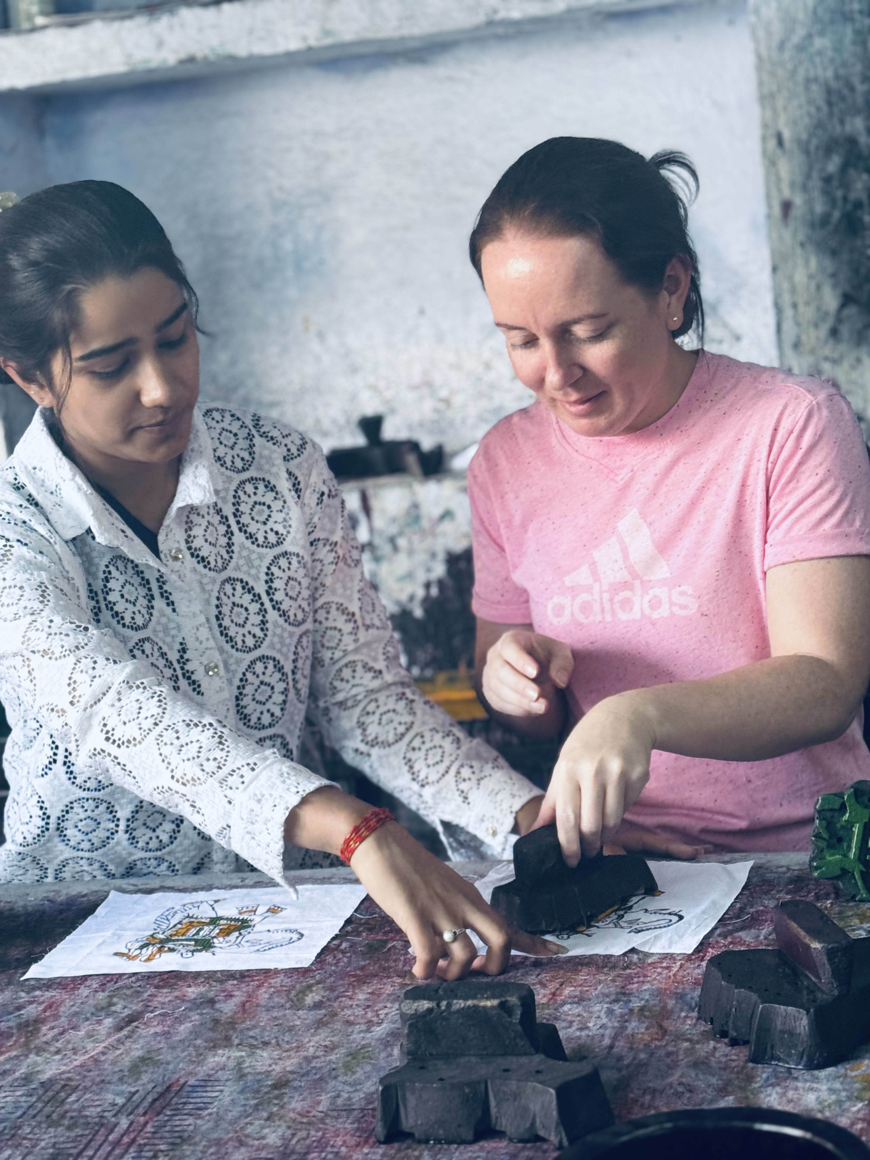 Travellers trying block printing at a workshop table