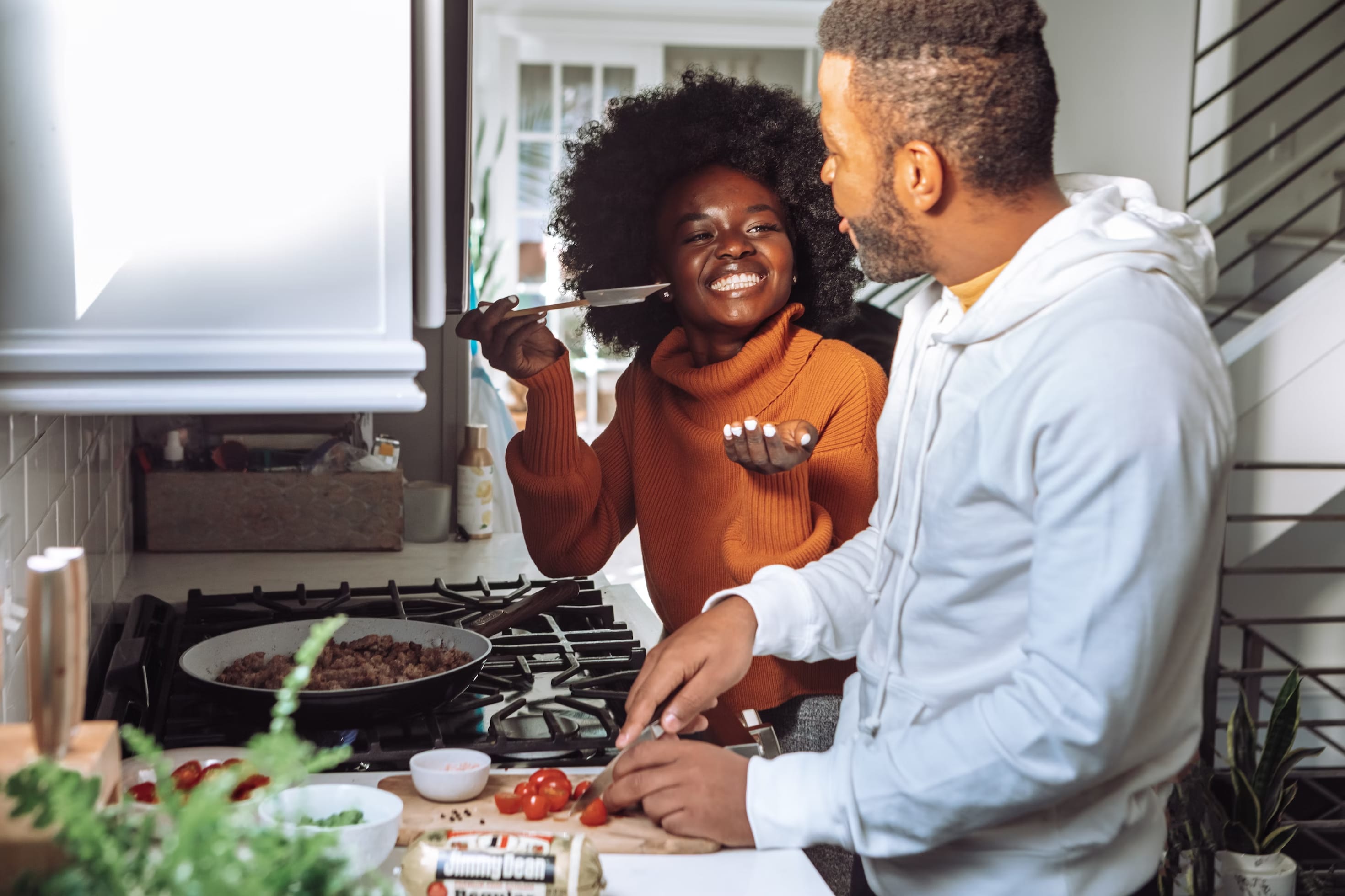 A couple tasting the food they are cooking