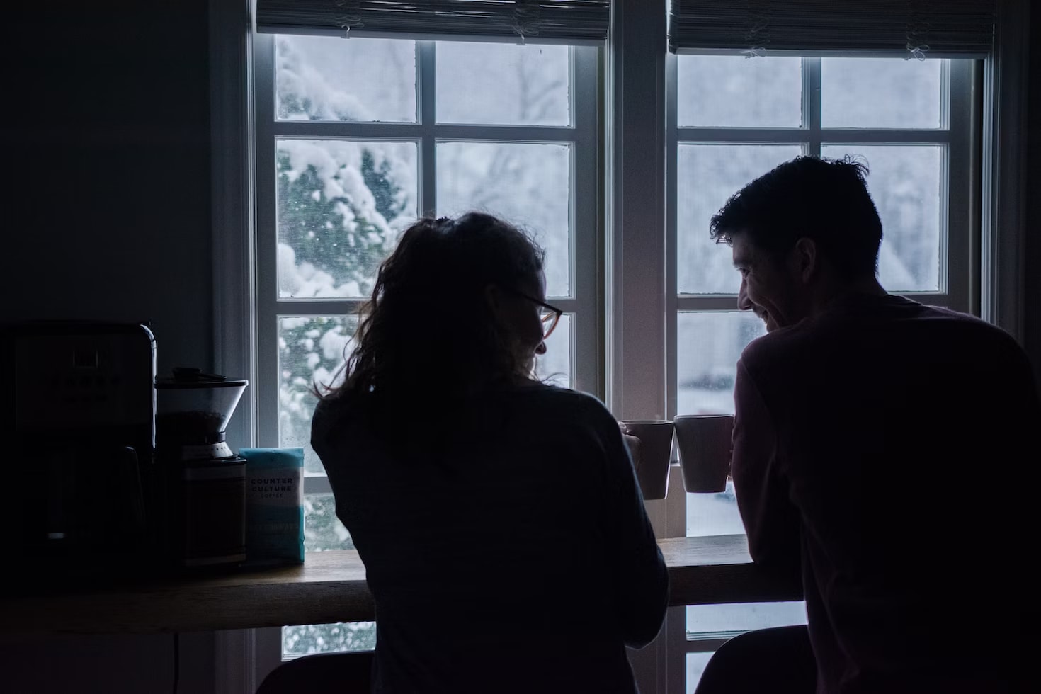 A couple's shadow seems from the background as they drink coffee together