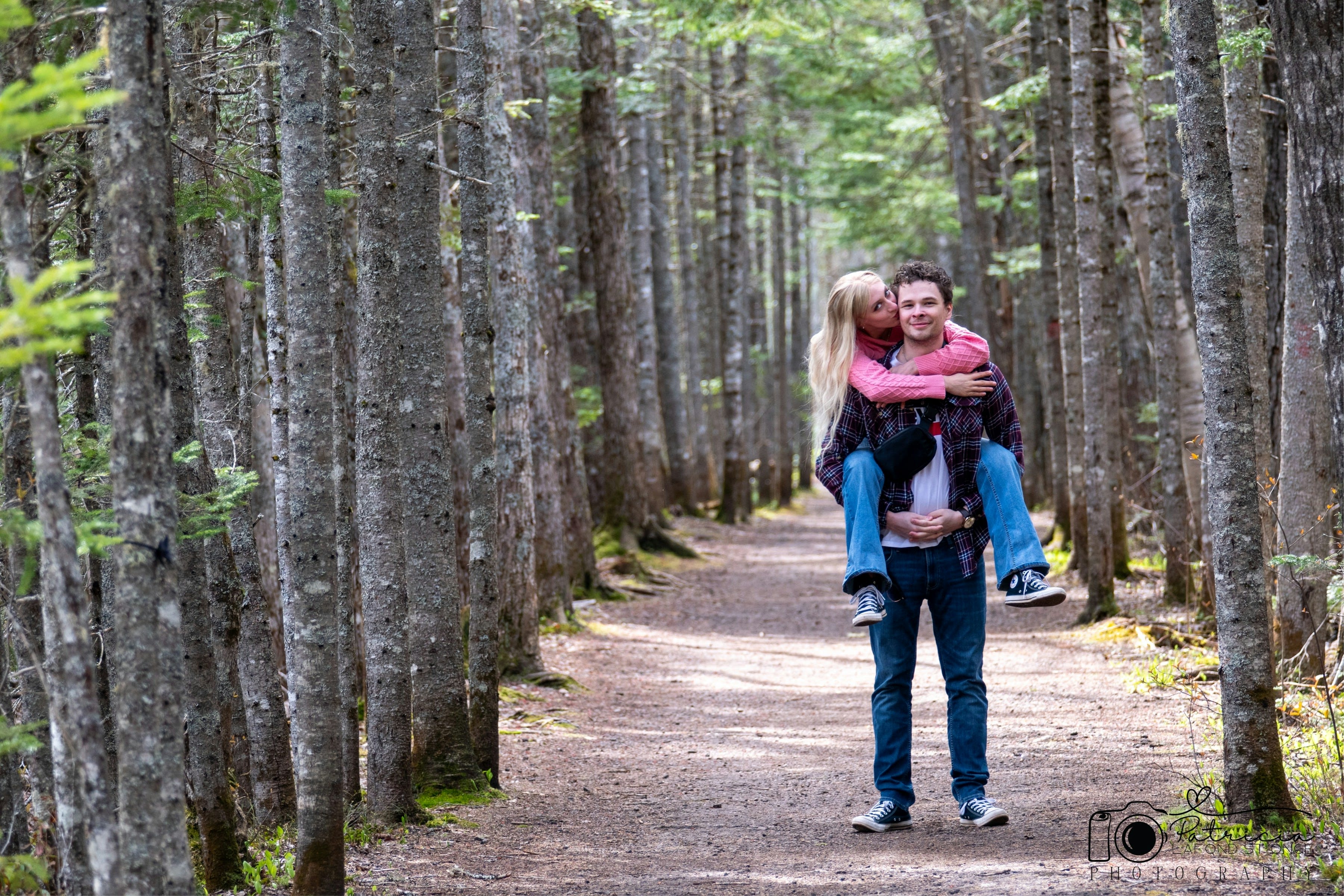 A girl piggybacking her partner in the forest