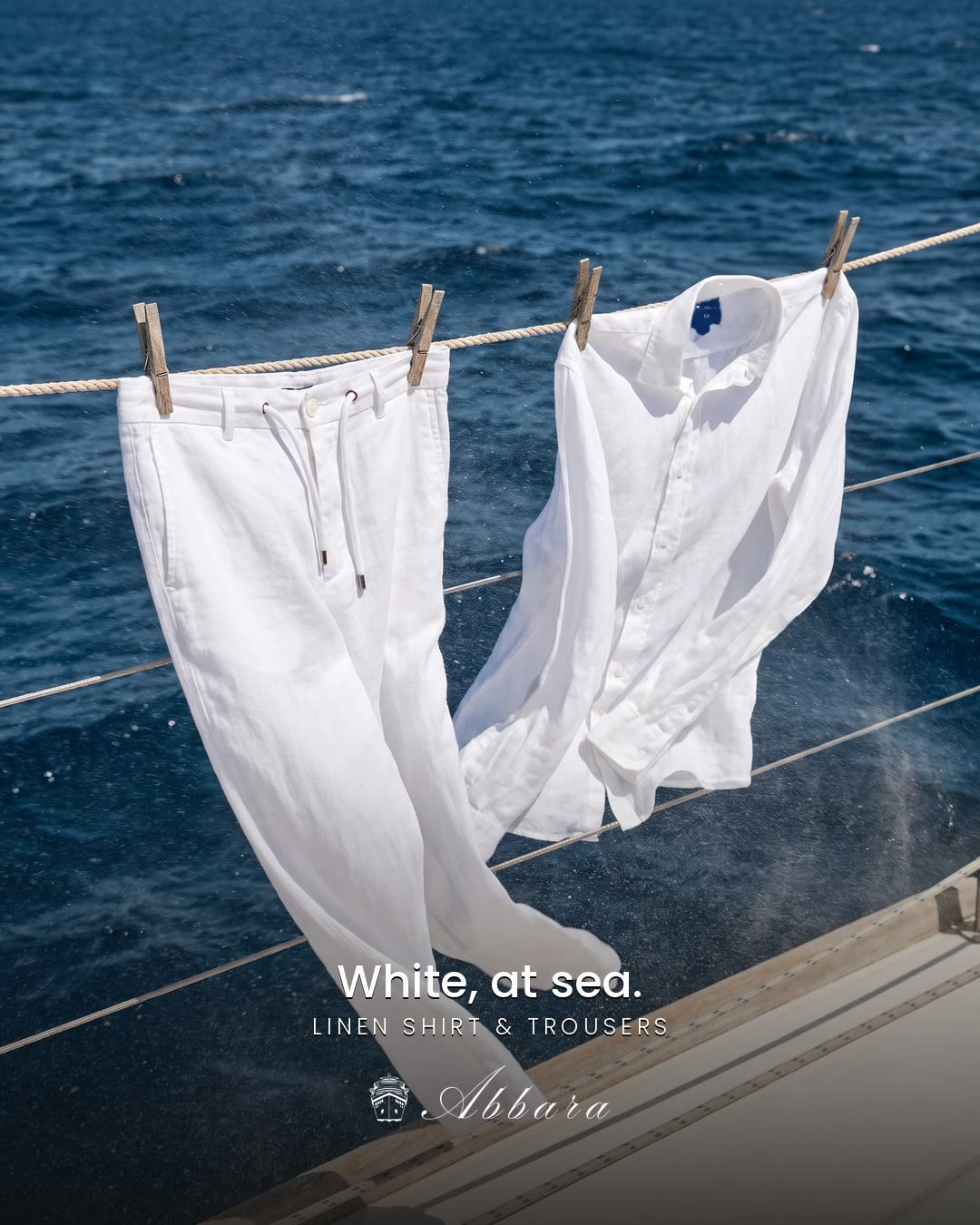 White linen shirt and trousers drying on a yacht against the sea