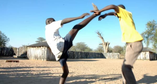 Engolo-Spieler in Angola, der linke führt einen hohen frontalen Halbmondtritt aus
