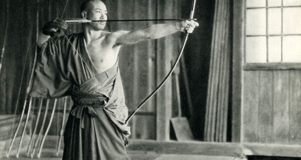 A kyūdōka at full draw with the asymmetric daikyū longbow